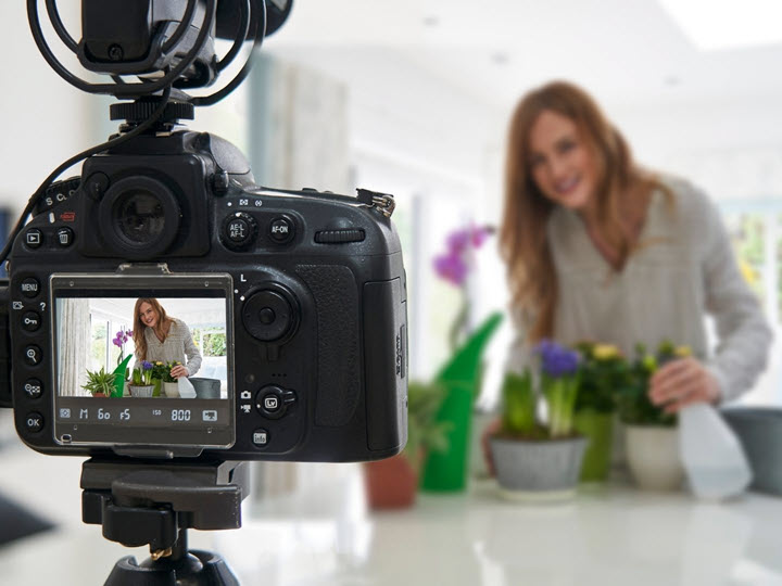Video camera focused on a woman with house plants
